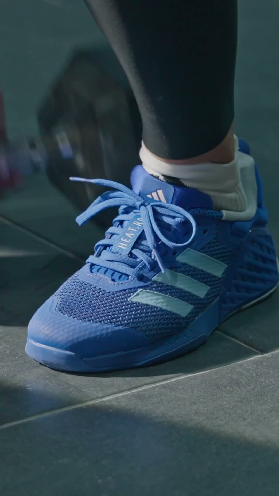 Low angle tracking shot of trainers on gym flooring