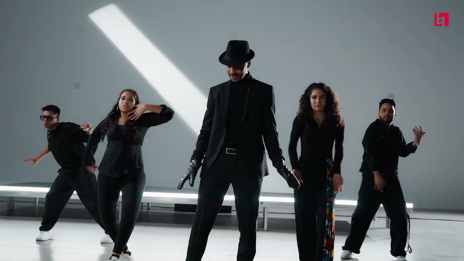 Dancers dressed in black on a white studio floor