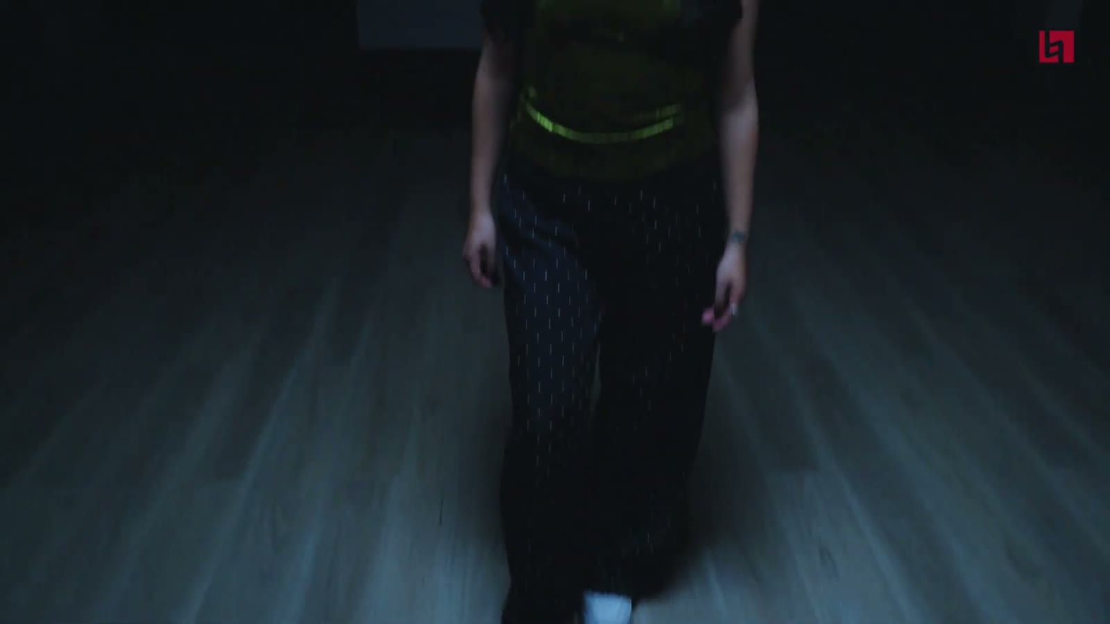 Figure walking through a dark corridor